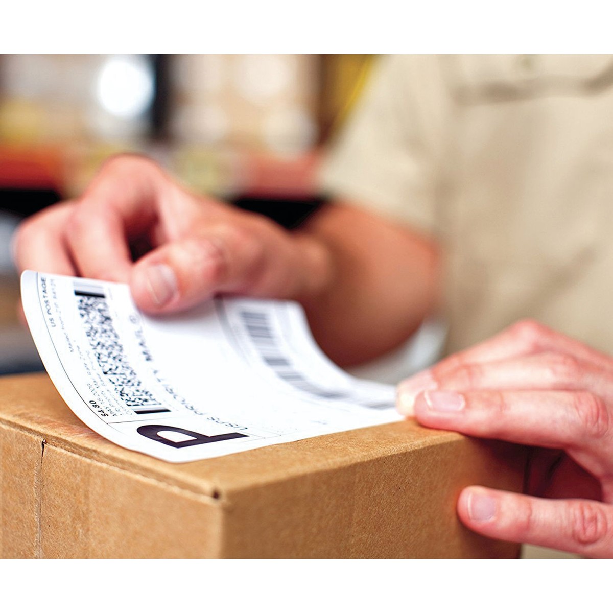 Hands applying a printed label to a carton