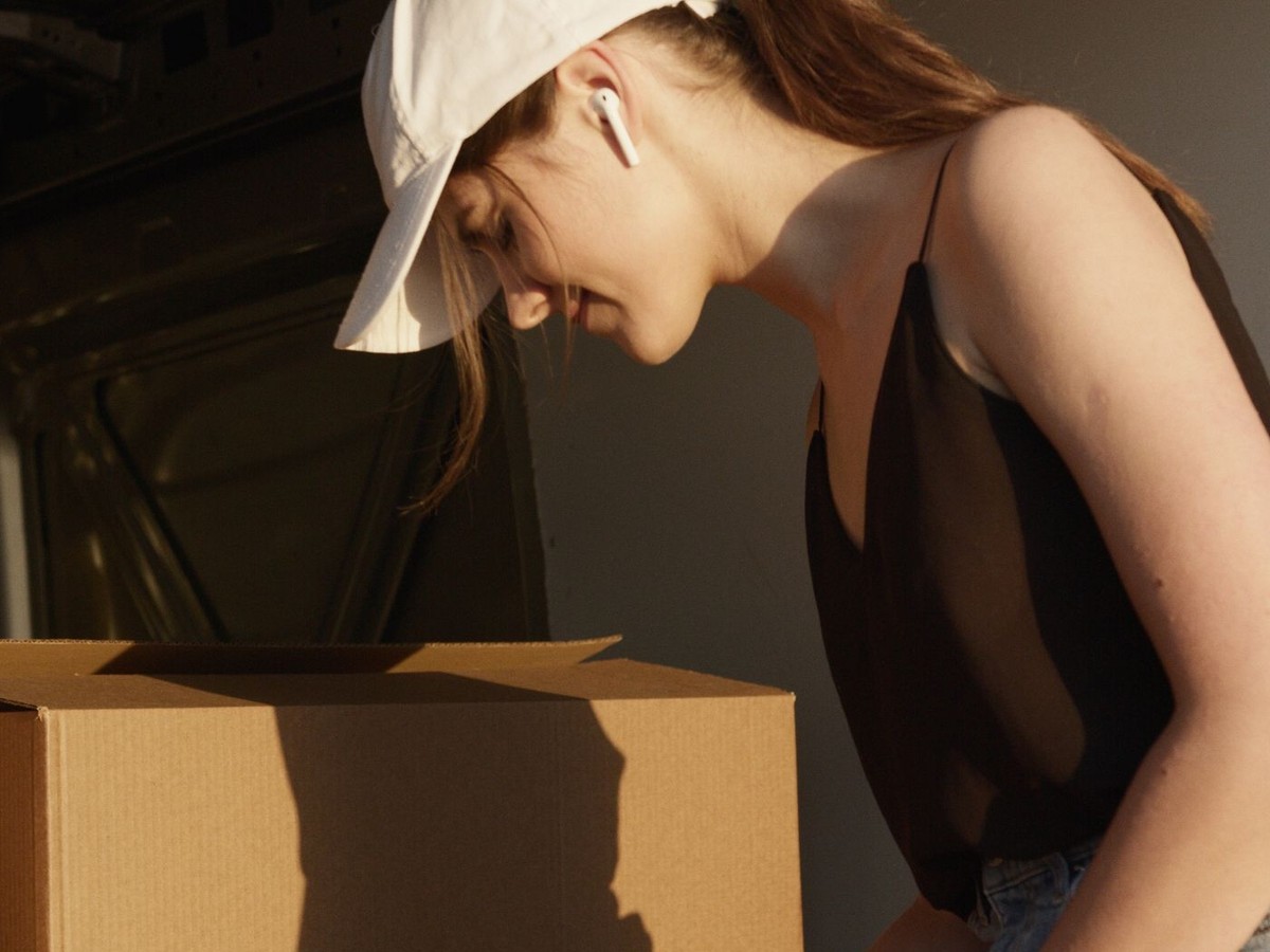 A warehouse worker checking cartons with a clipboard